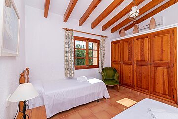 A bedroom with two beds and a green chair