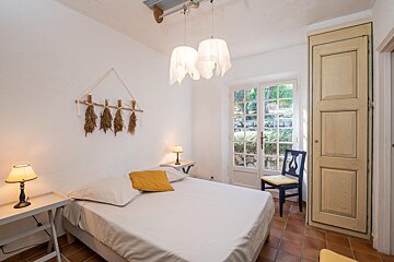 A bedroom with a bed and two lamps