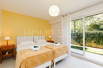 A bedroom with two beds and the word home on the wall