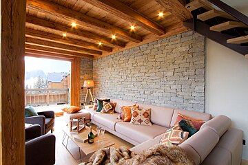 A living room with a pink couch and stairs