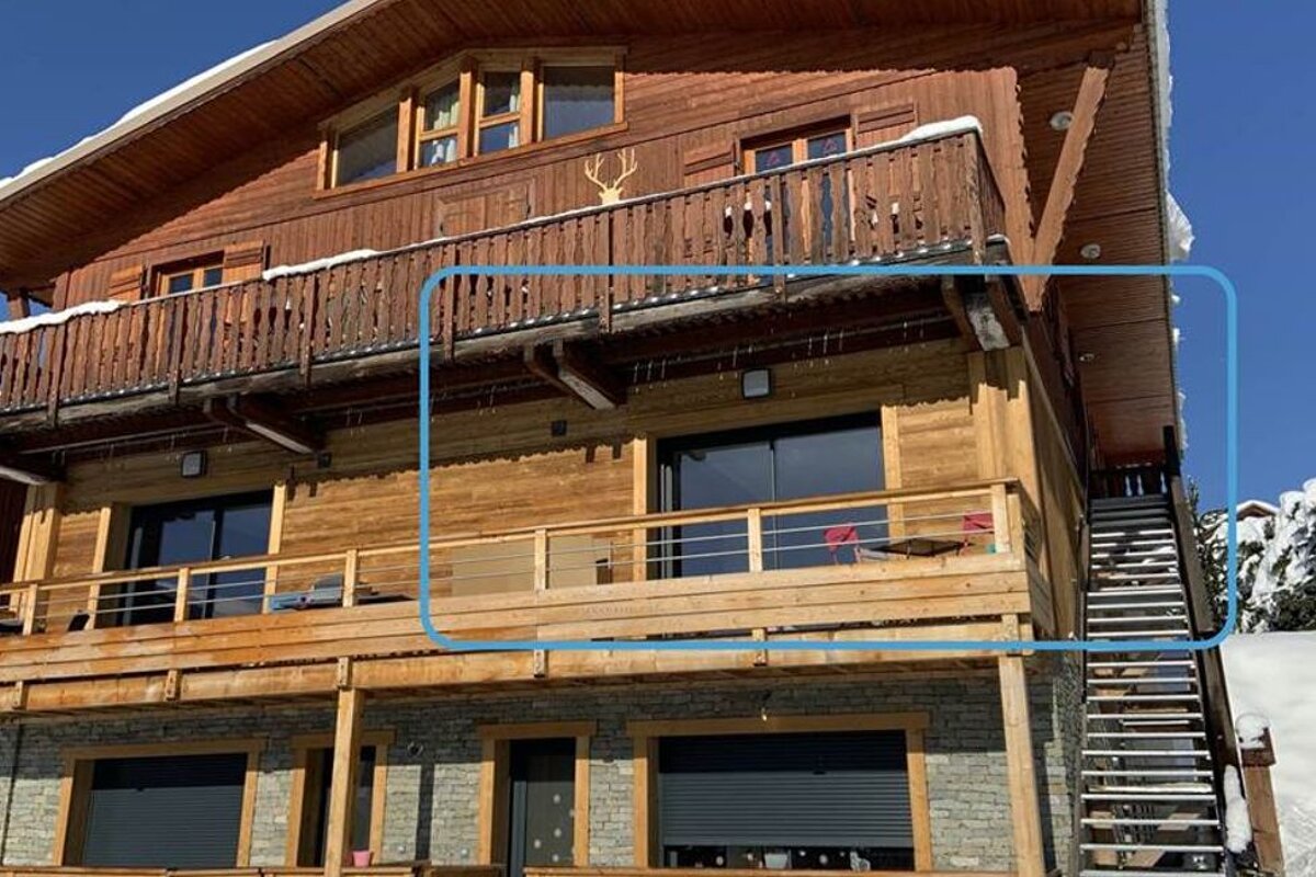 A large wooden house with a balcony and stairs