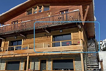 A large wooden house with a balcony and stairs