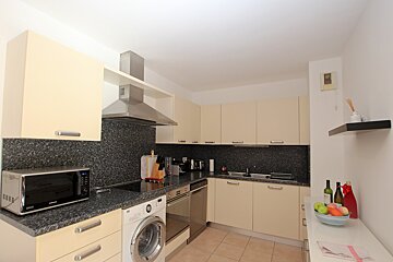 A kitchen with a microwave and a washing machine