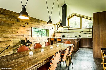 A kitchen with a wooden table and chairs and a sign that says ten80 holidays