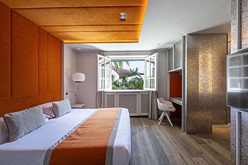 A hotel room with a large bed and a window