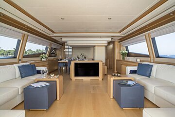 A living room with white couches and blue pillows
