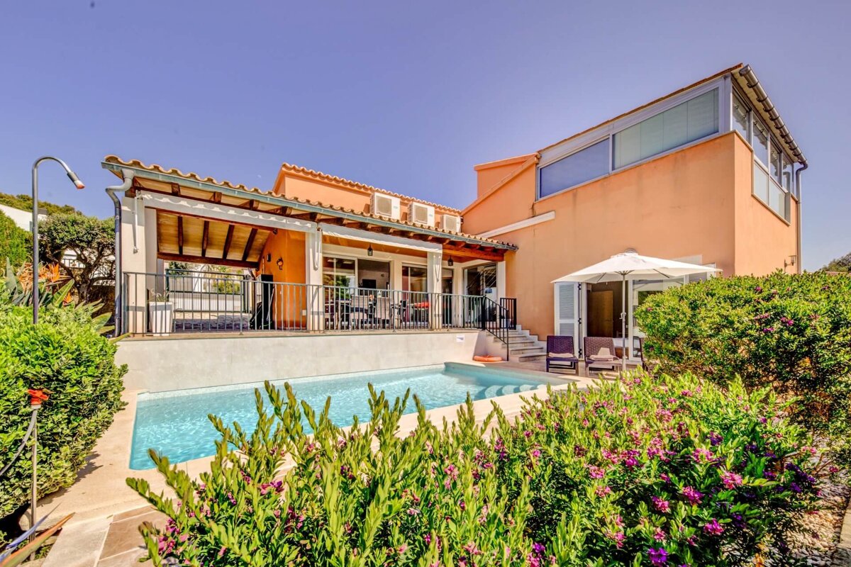 A large house with a swimming pool in front of it