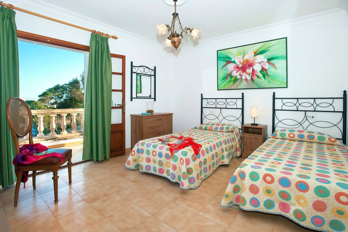 A bedroom with two beds and a painting on the wall