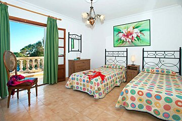 A bedroom with two beds and a painting on the wall