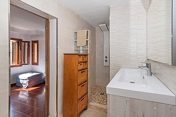 A bathroom with a sink and a wicker dresser