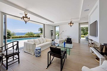 A living room with a couch and chairs and a television