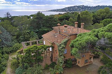 An aerial view of a large house surrounded by trees