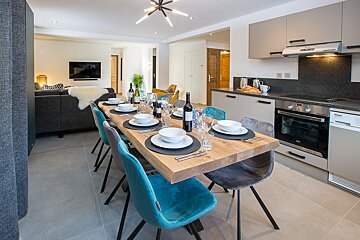 A dining room table with a bottle of wine on it