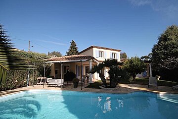 A house with a swimming pool in front of it