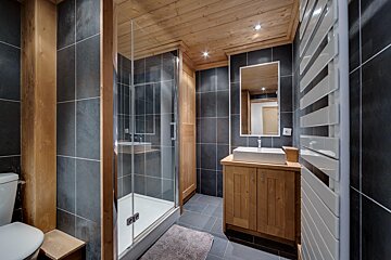 A bathroom with a walk in shower and a sink