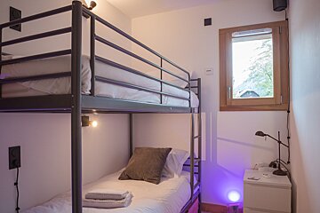 A bunk bed with a single bed underneath it