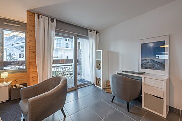 A room with two chairs and a picture on the wall
