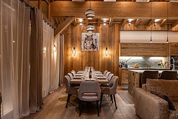 A dining room with a wolf painting on the wall above the table