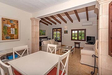 A living room with a table and chairs and a painting on the wall