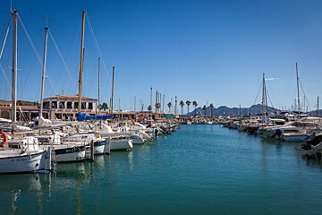 A row of boats are docked in a harbor and one of them has a license plate that says milen