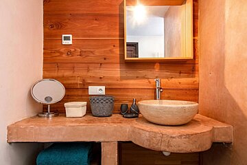 A bathroom with a sink a mirror and a thermostat