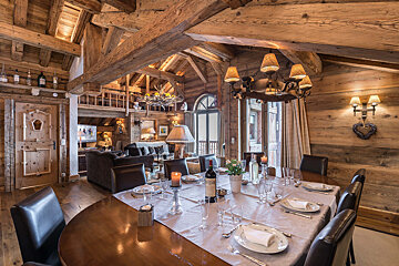 A dining room table with a bottle of wine on it