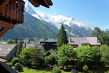 A view of a mountain range with houses in the foreground