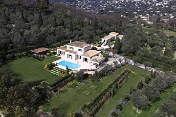 An aerial view of a house with a large swimming pool