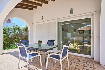 A patio with a table and chairs and a sliding glass door