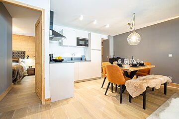 A kitchen with a table and chairs in it