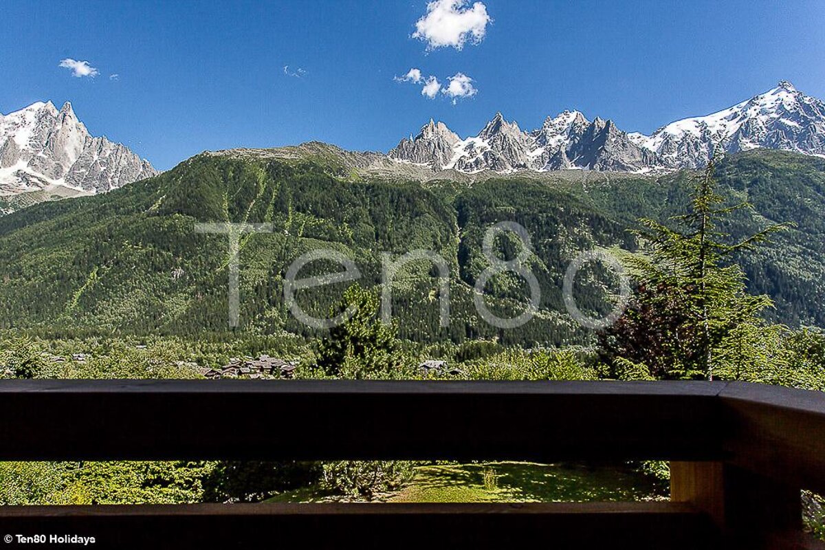 A view of mountains from a balcony with the words ten80 holidays visible