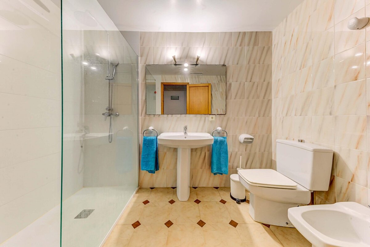 A bathroom with a sink toilet and walk in shower