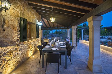 A patio with a table and chairs under a roof