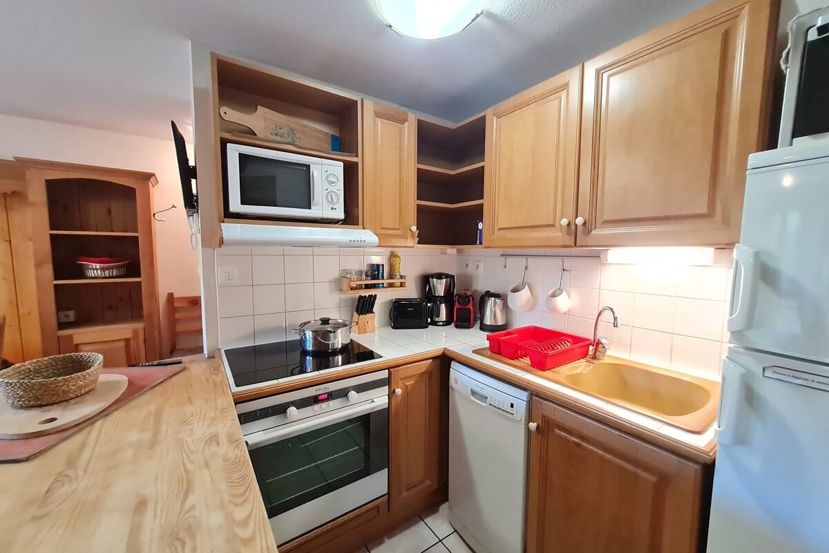 A kitchen with wooden cabinets and a white refrigerator