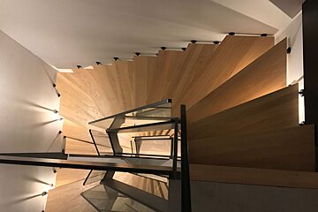 A spiral staircase with wooden steps and a glass railing