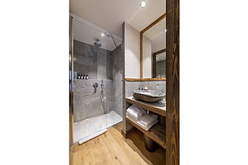 A bathroom with a sink and a walk in shower