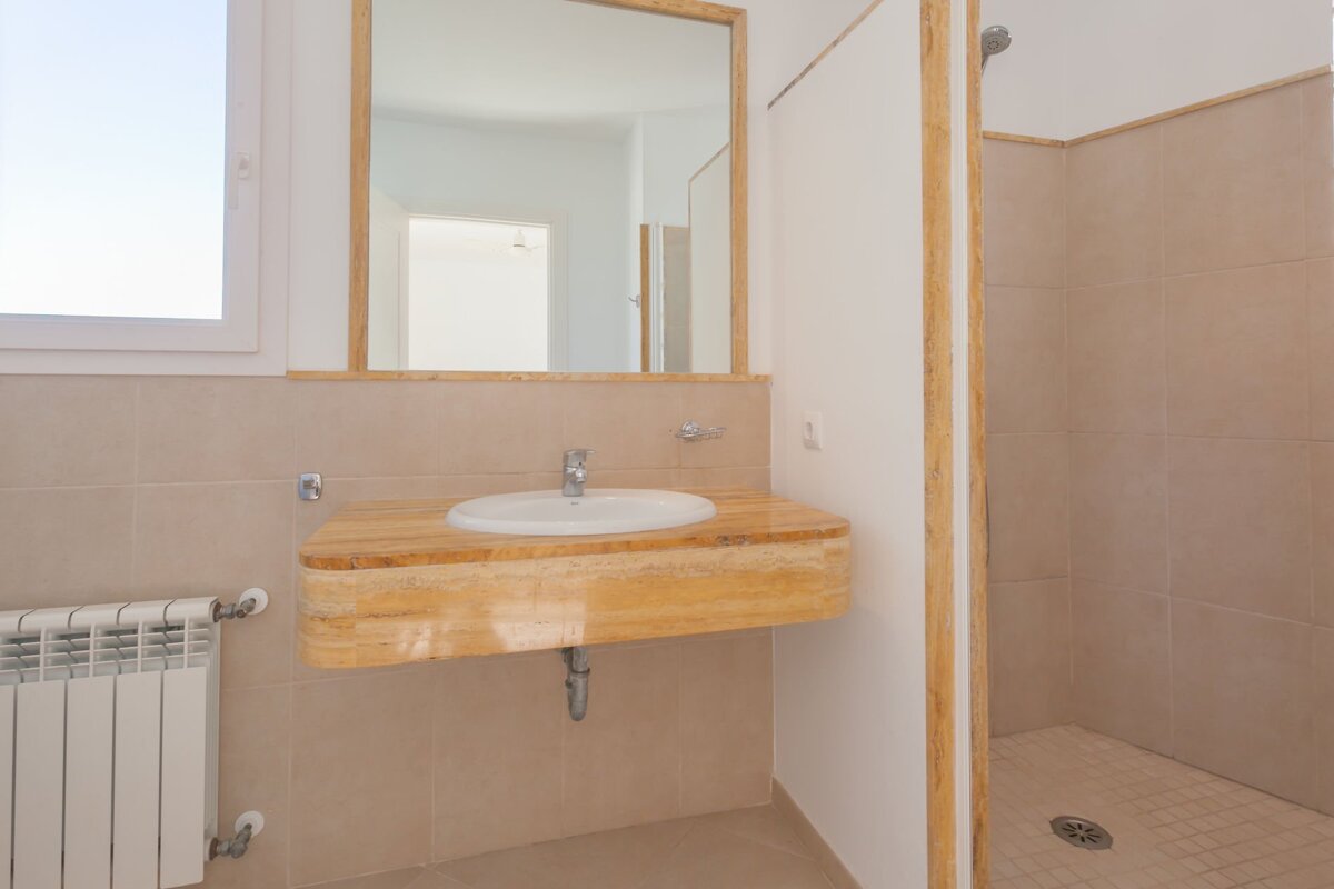 A bathroom with a sink a mirror and a radiator