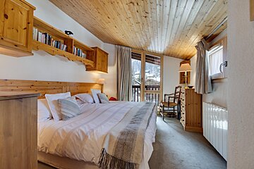 A bedroom with a king size bed and a dresser