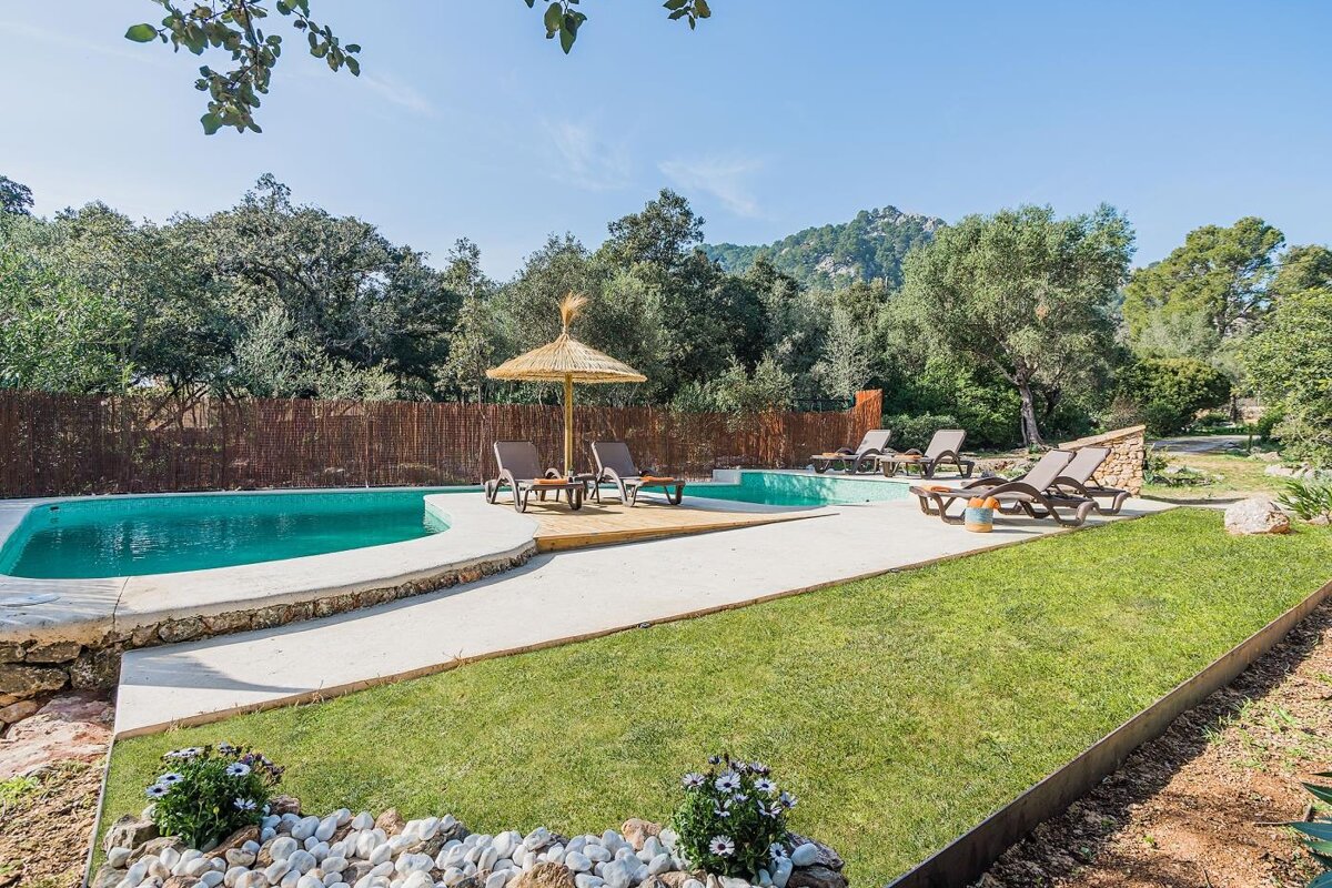 A swimming pool surrounded by chairs and a straw umbrella