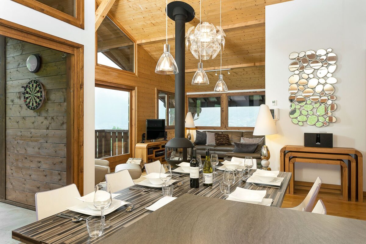 A dining room table with a bottle of wine on it