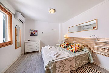 A bedroom with a large bed and a mirror