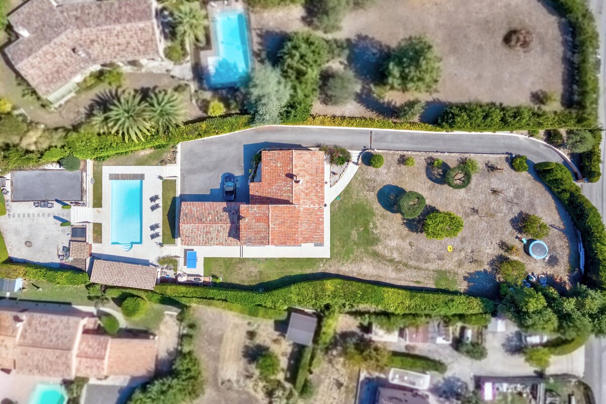 An aerial view of a house with a large pool