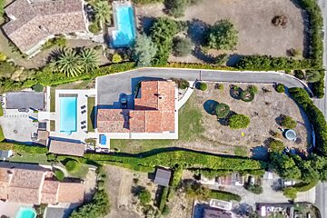 An aerial view of a house with a large pool