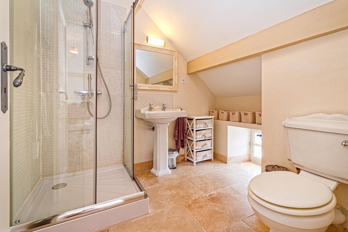 A bathroom with a toilet a sink and a walk in shower