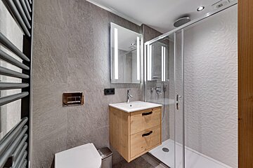 A bathroom with a toilet a sink and a shower