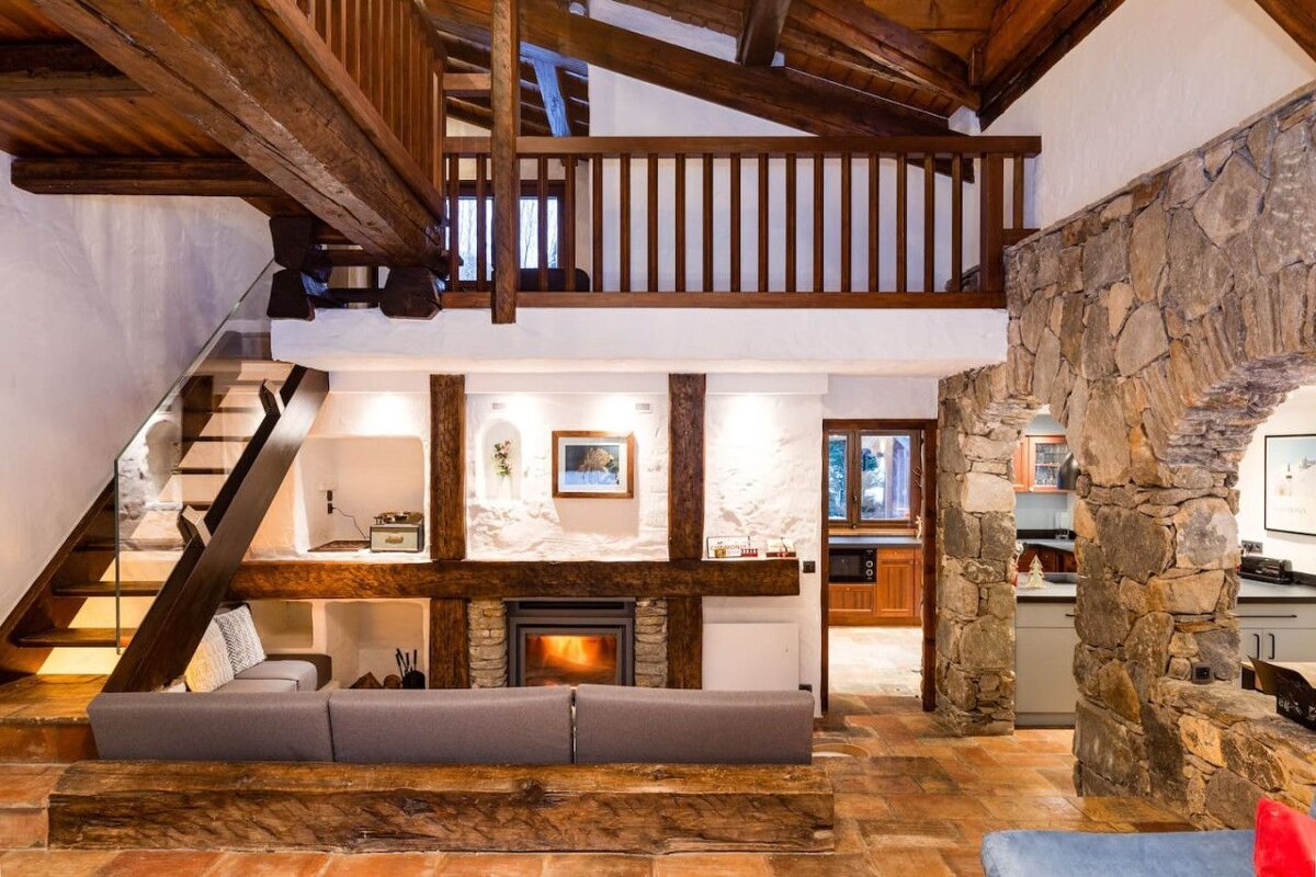 A living room with a fireplace and stairs leading up to the second floor