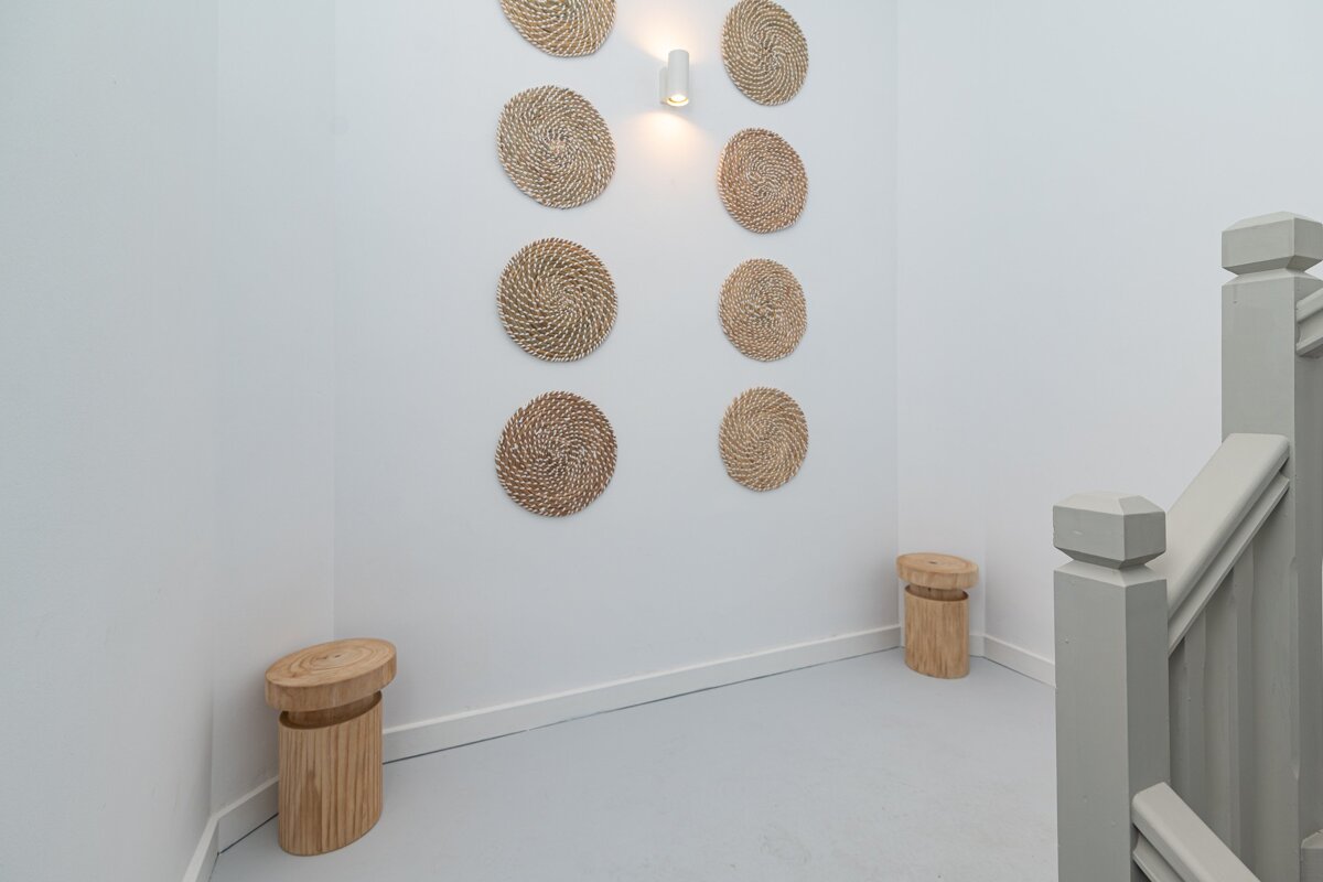 A staircase with wicker circles on the wall