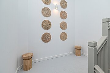 A staircase with wicker circles on the wall