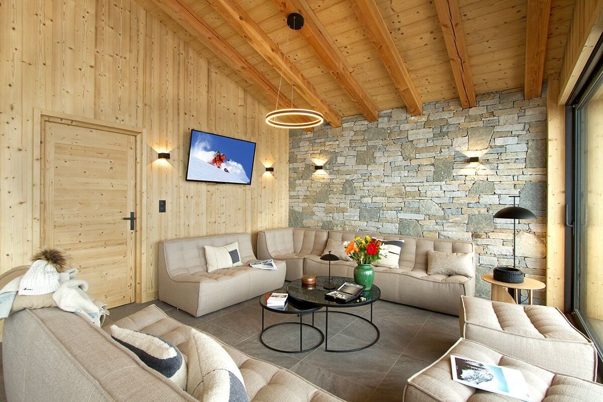 A living room with a stone wall and a flat screen tv