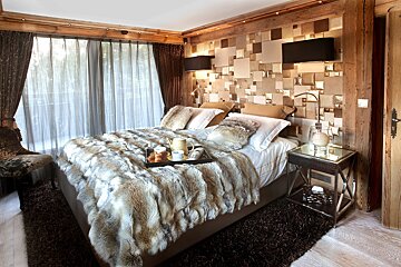 A bedroom with a fur blanket on the bed